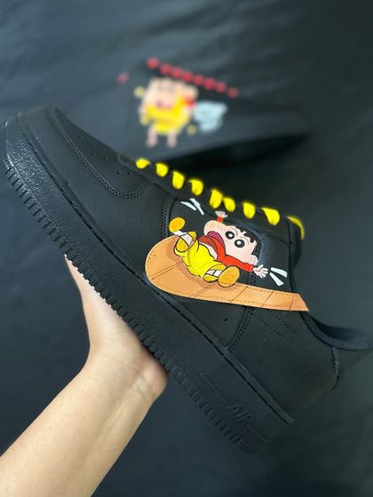 A close up of the Shin-chan artwork, where he's cheekily sliding down the Nike swoosh.