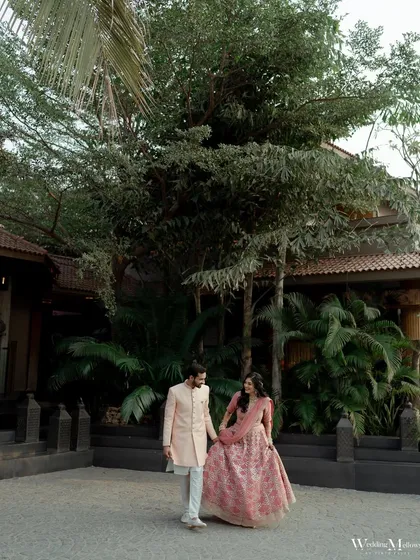 A classic portrait of the couple walking hand-in-hand at their engagement venue. This shot captures the grace and elegance of the occasion.