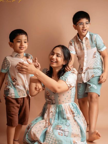 A candid and joyful moment between a mother and her two sons. Their coordinated outfits and playful interaction make for a heartwarming family portrait.