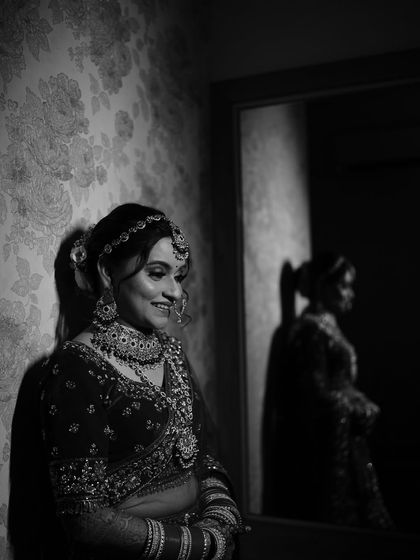 A beautiful black and white bridal portrait, capturing a quiet moment of reflection. The use of shadow and light adds depth and emotion to the image.
