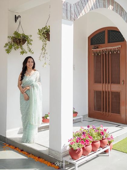 A full-length shot of the bride-to-be at her home, the beautiful flowers and decor adding to the celebratory feel of the Roka.