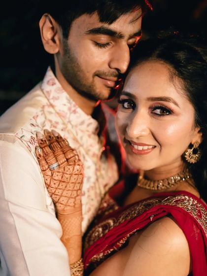 A beautiful portrait of the couple, with the bride looking directly at the camera, showcasing her henna and happy smile.