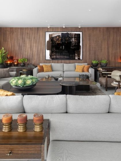 A wide view of the Camellias living room, demonstrating how we use furniture to define space. The L-shaped sofa carves out a cozy corner, while the arrangement of armchairs and console tables creates a sense of balance and flow, leading the eye towards the art and windows.