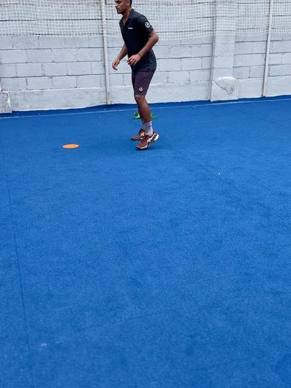 An athlete finishing a lateral sprint and transitioning into a forward sprint. This drill trains the body to change direction efficiently, a fundamental skill for covering the entire court in tennis.