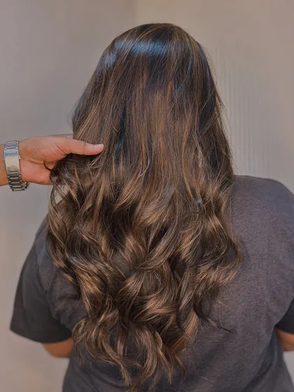 Our stylist's hand shows the texture and health of the hair after our color service. We always prioritize keeping your hair strong and shiny.