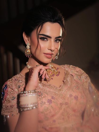 A stunning close-up of the bride. The makeup focuses on a flawless, sculpted base and captivating eyes, creating a look that is both powerful and delicate.