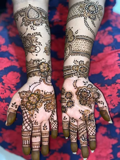 A flowing floral vine design that gracefully moves across the hands and up the arms, a classic choice for an elegant Arabic mehandi look.
