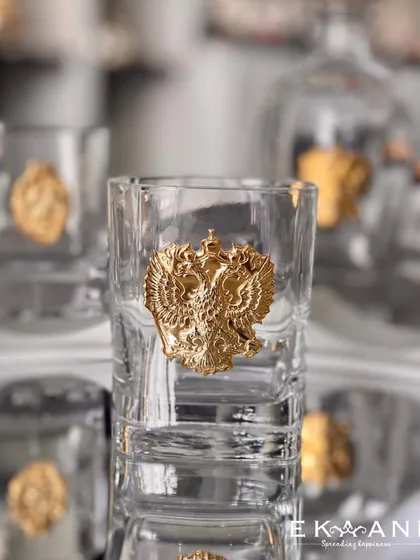 This whiskey glass features a powerful, gold-plated double-headed eagle emblem, a symbol of heritage and power. It is a piece that commands respect and admiration.