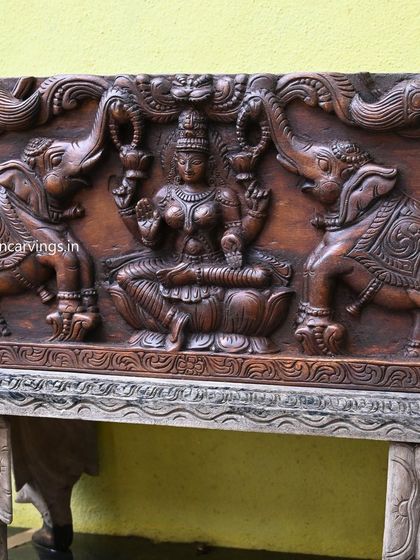 Another view of the central Gaja Lakshmi motif, highlighting the texture of the wood and the depth of the carving.