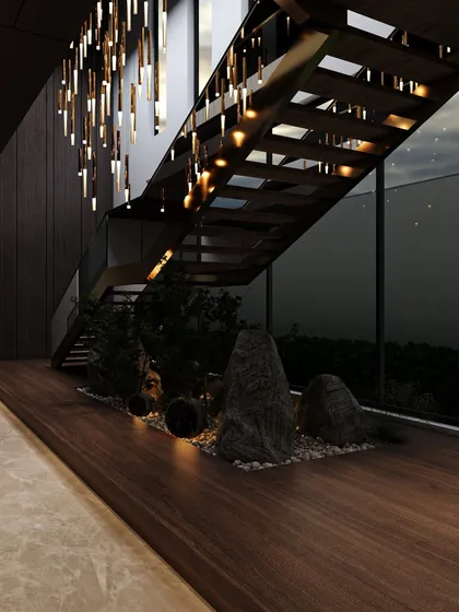 Another view of the staircase with the indoor rock garden, highlighting the dramatic effect of the cascading pendant lights against the dark wood wall.