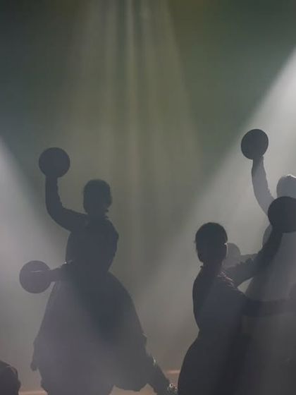 Our dancers are our soldiers, the strong pillars of our productions. This silhouette captures their synchronized energy and dedication during a group performance, holding 'manjeeras' (cymbals).