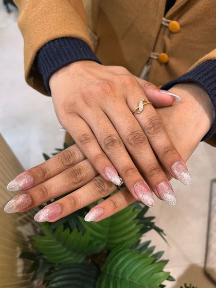 A beautiful set of silver cat eye nails with a glittery finish, perfect for a glamorous night out.