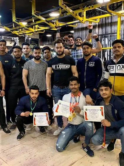 A gym full of champions. Posing with my clients and their medals after a successful competition season. This is the environment of success I cultivate.