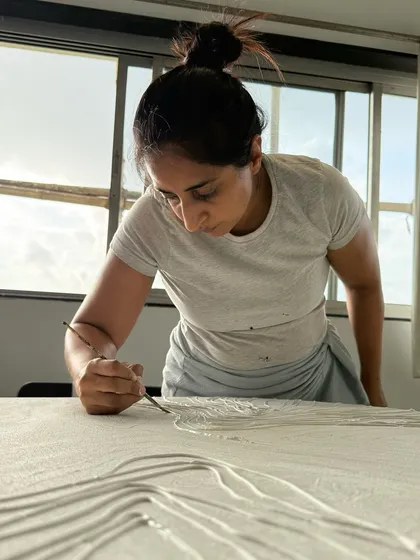 My hands at work, whispering an untold story into the canvas. Here, I am carefully refining the lines of a large textured piece, a process that requires both patience and a steady hand.