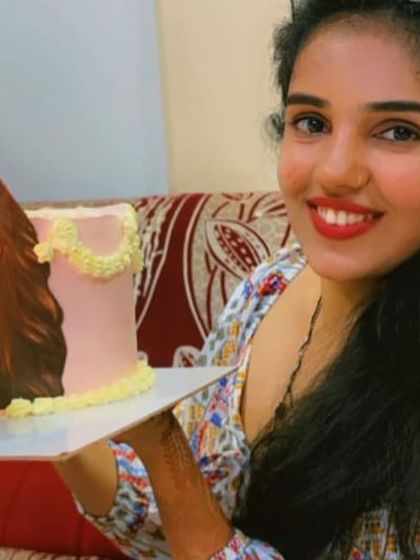 A close-up of our happy client and her unique blow-out cake.