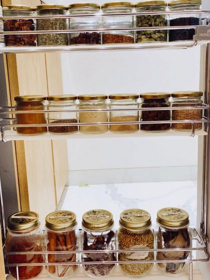 A beautifully organized spice drawer using a tiered rack. This setup allows you to see all your spices at once, making it easy to find what you need while cooking.