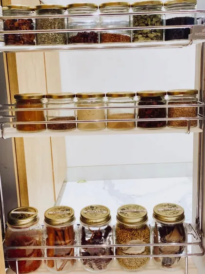 This pull-out spice rack is a fantastic solution for narrow cabinets. We used uniform glass jars to keep all the spices visible and tidy.