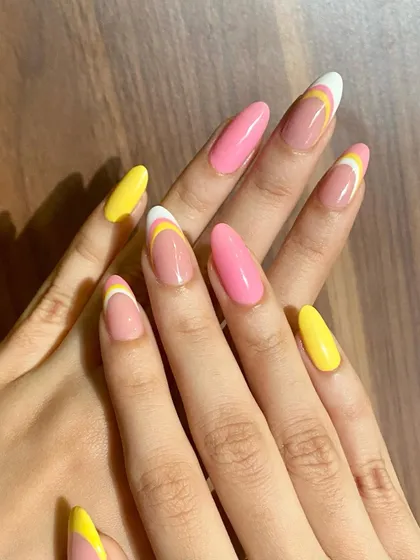 A bright and cheerful set with a mix of solid pink and yellow nails and abstract French tips.