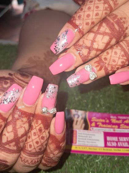 A fun and vibrant bridal look. These square-shaped nails in a bright pink are perfect for pre-wedding functions. We added silver foil accents and 3D stone bows for extra sparkle.