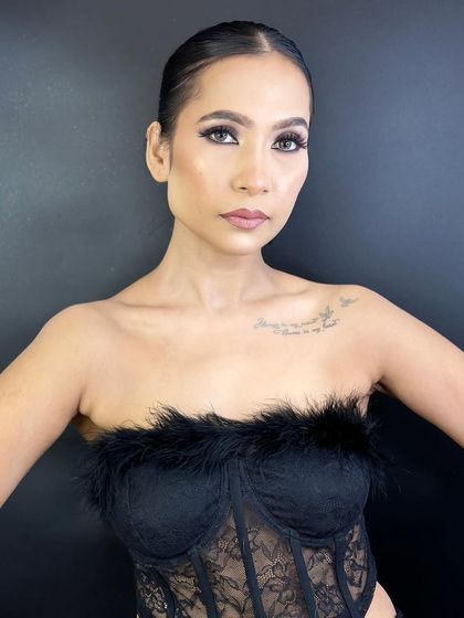 A full shot of the model in a black lace corset, showing how the smokey glam makeup completes the entire look.