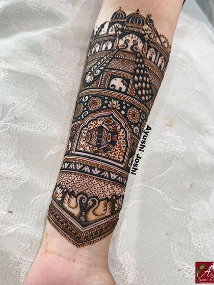 A close-up of the forearm, detailing the dhol-shehnai and kalash motifs, essential symbols in an Indian wedding celebration.