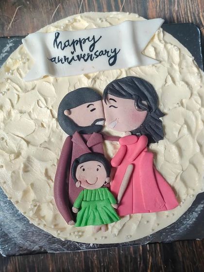 A small little world of ours. This sweet anniversary cake features a rustic buttercream finish and is topped with a hand-drawn style fondant plaque of the family.