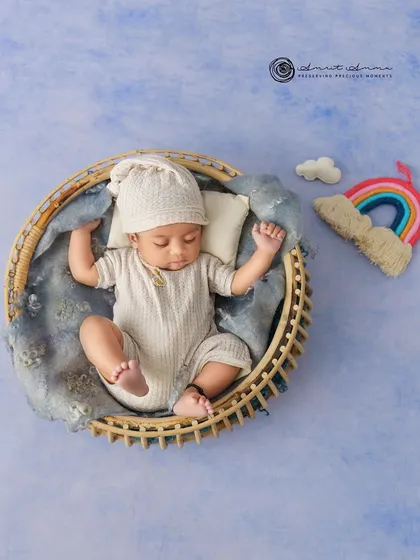 A top down view of the rainbow theme, showing the baby peacefully sleeping under a sky blue backdrop with a little cloud and rainbow.