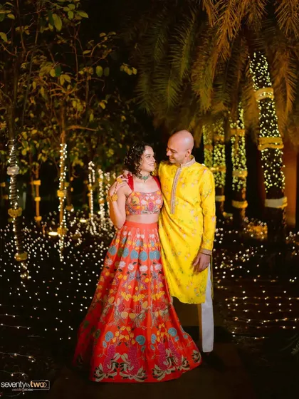 A beautiful nighttime portrait of the couple during their Mehendi or Sangeet, surrounded by twinkling fairy lights.