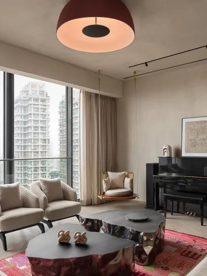 In this urban apartment, we balanced a neutral, textured palette with bold, sculptural furniture and vibrant art. The design creates a sophisticated living area that feels both dynamic and inviting, with large windows framing the city skyline.