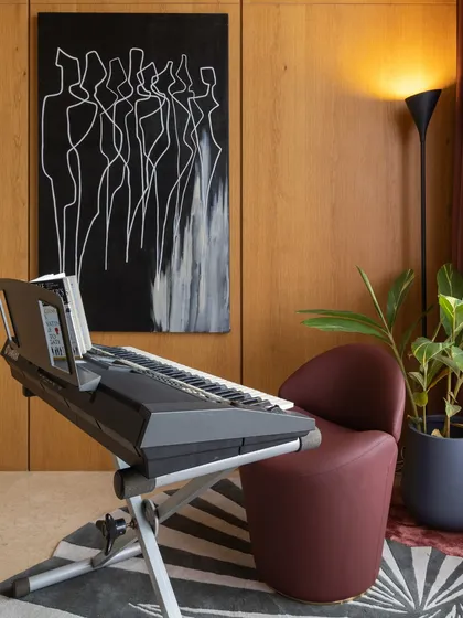 You don't have to be traditional just because you have a classic element like a keyboard. This music room pairs it with modern art and a bold red armchair for a cool, eclectic vibe.