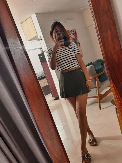 A casual look with a striped tee and a mini skirt, showcasing a sporty and relaxed style.