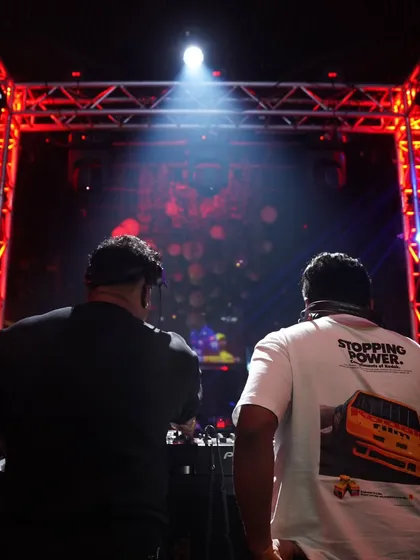 A view from behind the console, looking out at the stage and the crowd. This perspective shows the scale of the event and the connection between the DJs and the audience.