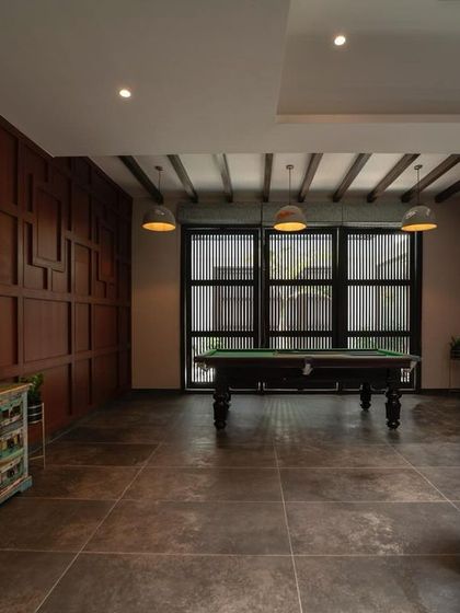 Another view of the rustic game room, showing the full wood-paneled walls and simple, effective lighting. The design creates a cozy, club-like feel within the home.