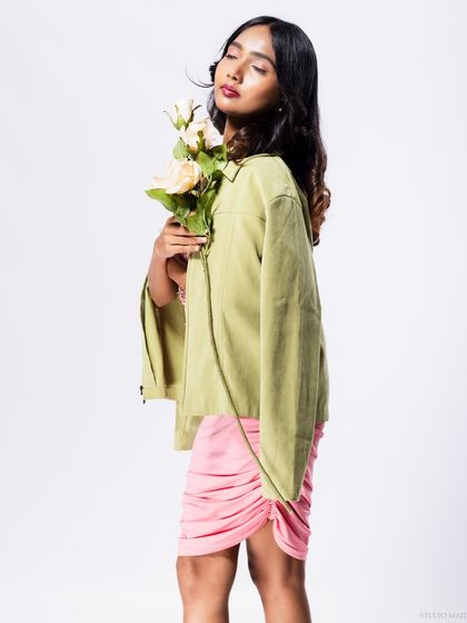 A full-body shot of the model in the pink dress and green jacket.