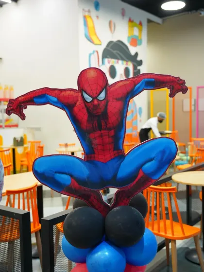 A Spider-Man cutout on a balloon column adds to the superhero action. We use props like these throughout the venue to enhance the party theme.