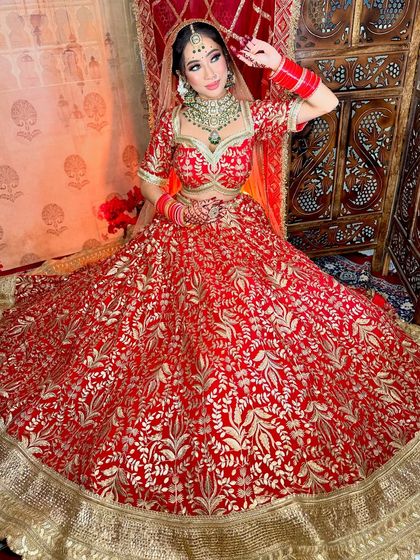 The full view of the bride's magnificent lehenga. The makeup is balanced to complement the heavy embroidery and jewelry.