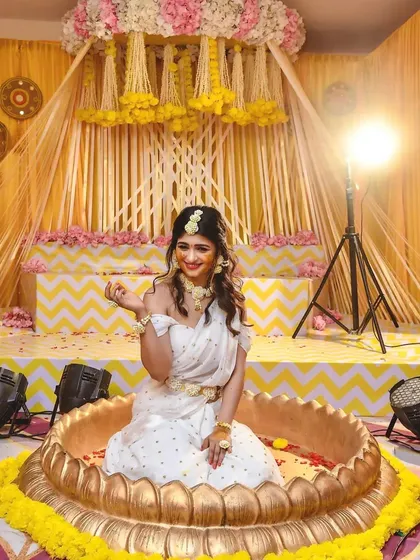 It was pure joy creating this Haldi ceremony decor for actress Aditi. I designed a beautiful setup with a custom lotus-shaped uruli, surrounded by traditional marigold flowers and a vibrant yellow and white backdrop for a festive and happy celebration.