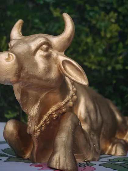 A close-up of a traditional golden cow statue, an important cultural element beautifully integrated into the South Indian wedding decor.