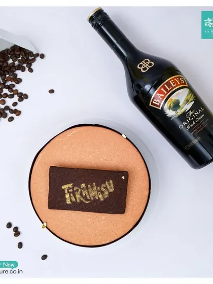 An overhead view of my Tiramisu with Baileys cake, showing the rich cocoa dusting and the elegant presentation next to coffee beans and a bottle of Baileys.
