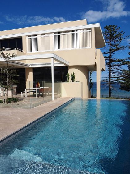 A coastal property with an infinity pool overlooking the ocean. Our design incorporates a clean, modern aesthetic that complements the stunning natural view.