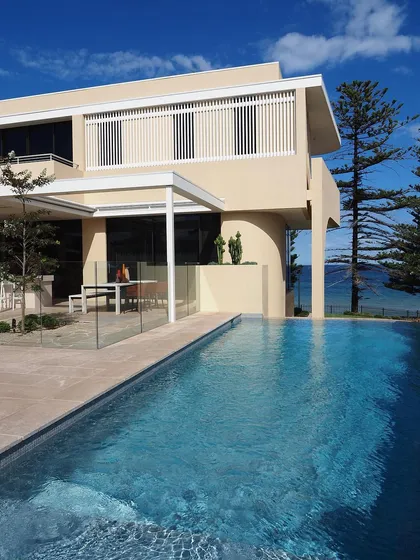 A coastal property with an infinity pool overlooking the ocean. Our design incorporates a clean, modern aesthetic that complements the stunning natural view.