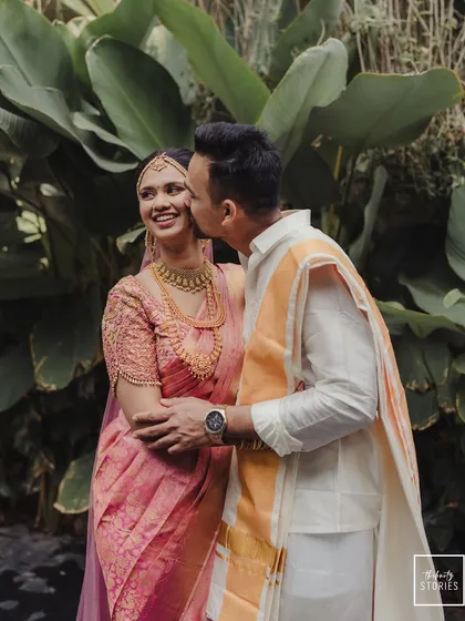 A sweet and candid moment of the groom kissing his bride's cheek.