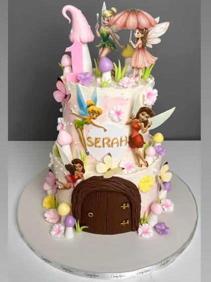 We built a tiny, enchanting world for this two-tiered fairy house cake. It features multiple hand-painted fairy figurines, sculpted mushrooms, and a detailed wooden door, all designed to capture the magic of a childhood storybook.