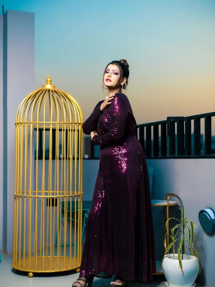 A full-length shot from a fashion portfolio shoot. I styled this entire look, pairing a glamorous purple sequin gown with coordinated dramatic purple eye makeup and a chic top-knot bun.