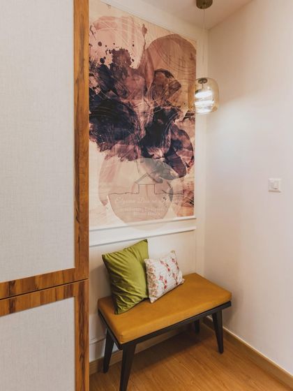 A close-up of the entryway seating nook, with a comfortable bench and vibrant cushions. This small space is designed to be both practical for putting on shoes and welcoming for guests.