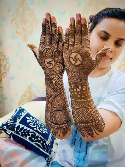 The client showing off her festive swastika mehandi, a perfect choice for religious ceremonies and festivals.