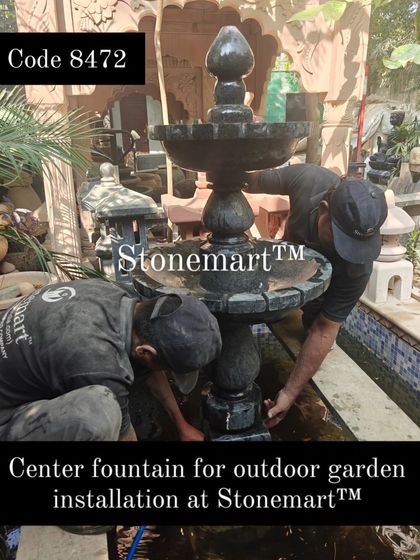 The final stages of installing the center fountain for an outdoor garden. The solid granite construction ensures it will withstand the elements for decades.