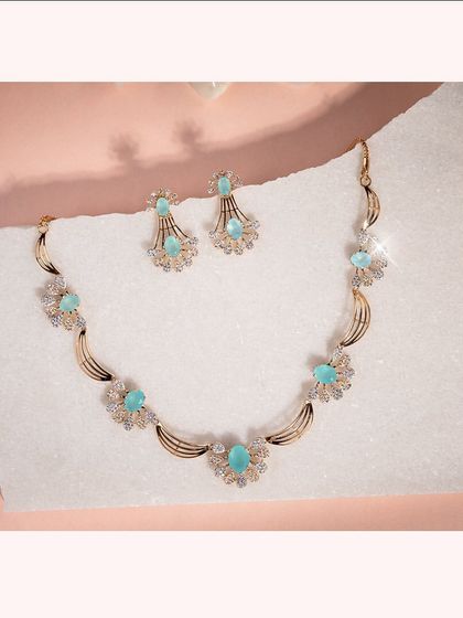 A stunning Italian necklace and earring set with light blue gemstones surrounded by CZ diamond halos.