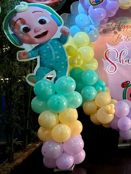 A close-up of a Cocomelon character cutout on a pastel balloon pillar for Shameen's first birthday.