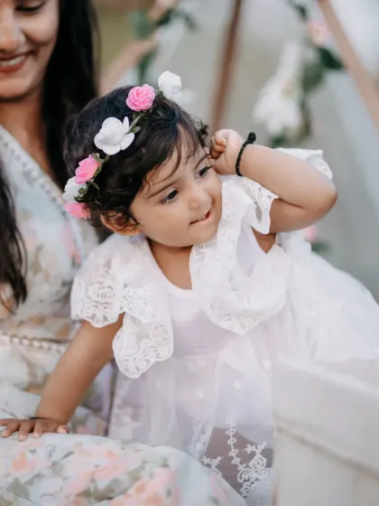 The pure, unfiltered joy of childhood. This close up portrait of a little girl in her lace dress and flower crown captures her playful spirit and sweet innocence during a family photography session.